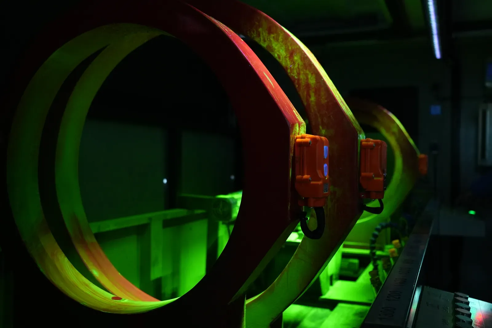 Magnetizing coils coated with fluorescent magnetic suspension, glowing green under UV-A light